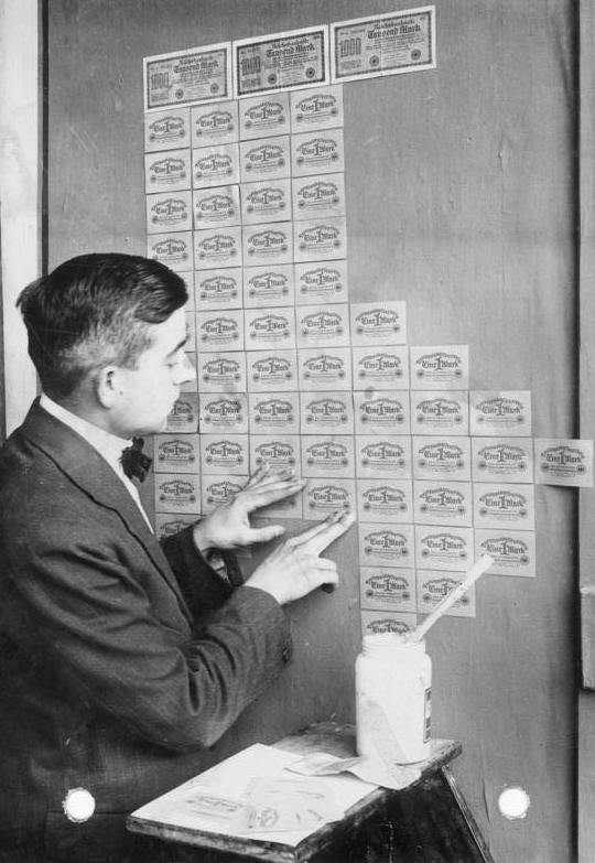 Хиперинфлация в Германия през 20-те - човек използва банкноти вместо тапети
